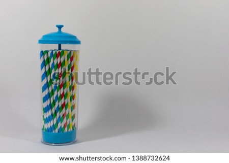 Retro style container of colourful paper straws isolated on a white background, alternative to single use plastic, to reduce pollution and waste