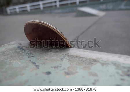 Close up of skateboard leaning against an obstacle at a beachside skate park.