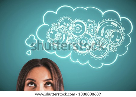 Portrait of attractive young businesswoman thinking of cogwheels sketch on blue background. Teamwork and machinery concept 