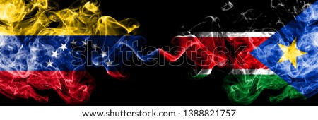 Venezuela vs South Sudan smoky mystic flags placed side by side. Thick colored silky smoke flags of Venezuela and South Sudan.