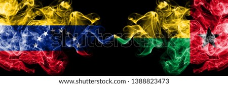 Venezuela vs Guinea Bissau smoky mystic flags placed side by side. Thick colored silky smoke flags of Venezuela and Guinea Bissau.