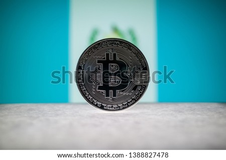 Physical silver version of Bitcoin (BTC) and Guatemala Flag on the background. Conceptual image for investors in cryptocurrency and Blockchain Technology.