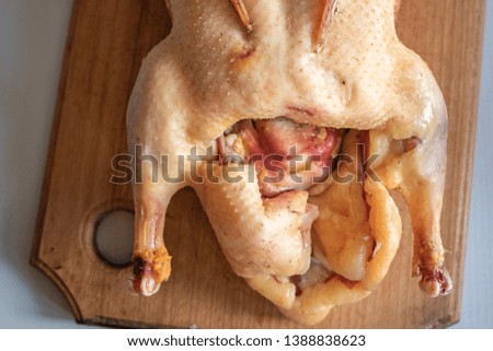 raw bird carcass on a cutting board.