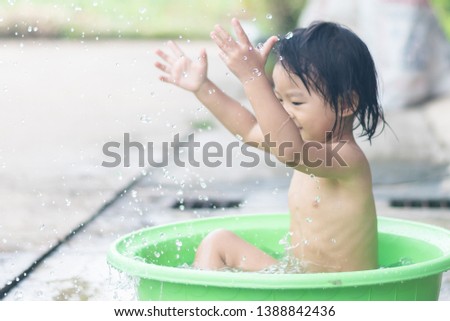 little children sit in basin and had fun playing water