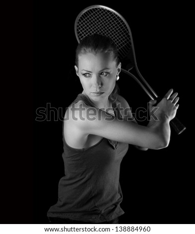Ready to hit! Female tennis player with racket ready to hit a tennis ball. On black.