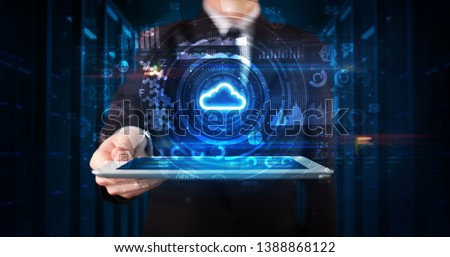 Hand holding tablet with cloud technology and dark concept Royalty-Free Stock Photo #1388868122