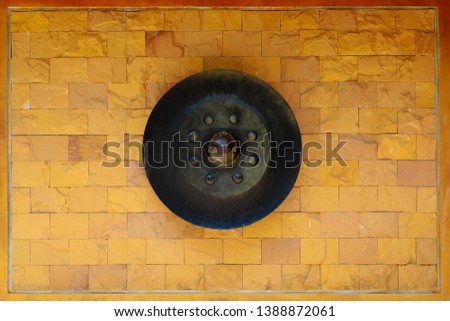 Gong hang on the bricks wall