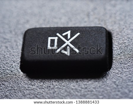 Silence, please. Extreme closeup of the Mute button of a remote control device. Prevent sound pollution, conceptual image.  Royalty-Free Stock Photo #1388881433