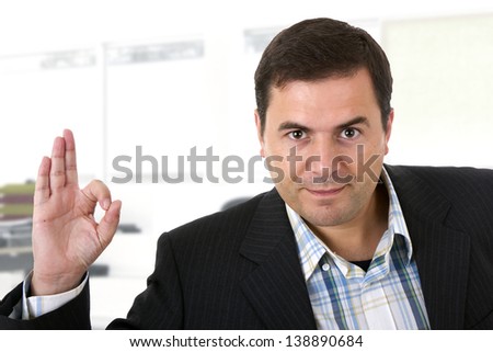 businessman smiling doing the ok sign in office