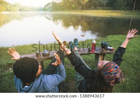 Asian couples feel relaxed and happy with morning drinking coffee by the lake. Couple romantic traveling camping, Honeymoon.
