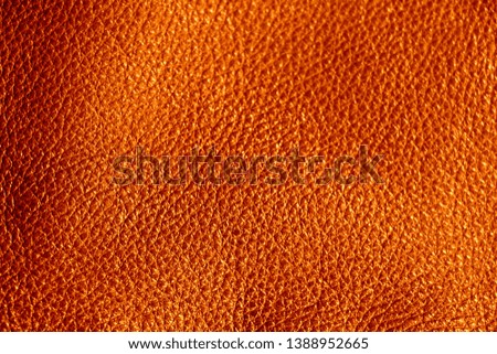 Texture of genuine leather. 
Orange background.