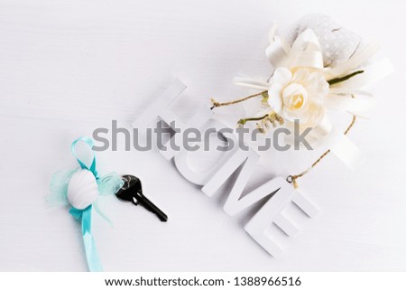 Nordic style still life on a white wooden background with wooden letters with the inscription Home and keys house, the concept of home or home purchase