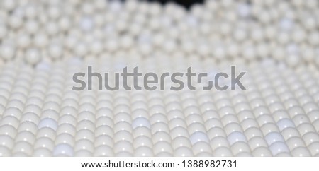 strict and straight rows of ideal round white balls and spheres similar to chicken eggs, medical tablets, billiards balls, airsoft balls