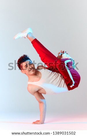 Asian Bboy standing in freeze stunt upside down balancing in air with legs - Street artist breakdancing indoors isolated in studio over white background Royalty-Free Stock Photo #1389031502