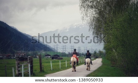 two girls ride horses in a field