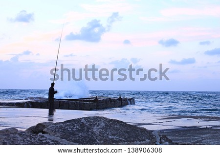 man fishing in the early morning in a storm