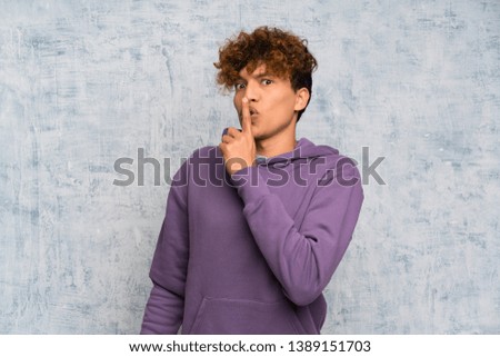 Young african american man over grunge wall doing silence gesture