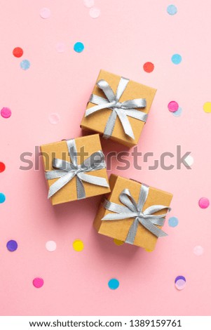 Gift or present boxes and color confetti on pink table top view. Flat lay composition for birthday, mother day or wedding