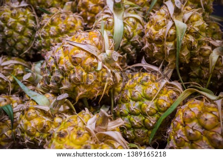A pile of ripe yellow pineapple with leaf in the market