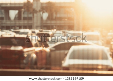 Blurred full outdoor parking lots with a lot of cars parked inside during the sunset