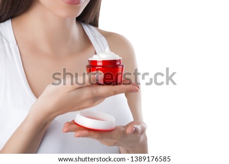 Young beautiful woman applying face cream. Female on isolated white background. Face care. Facial portrait of attractive lady.