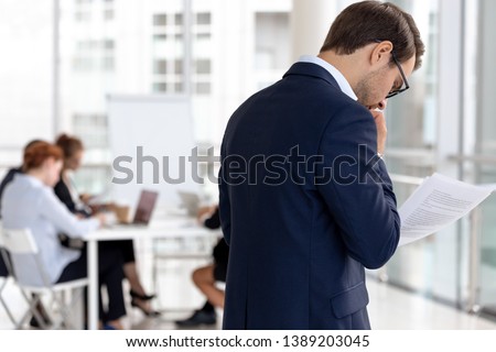 Worried male speaker stand outside conference room read notes feel scared to enter boardroom, anxious frightened man presenter repeat read paperwork report, afraid of public speaking Royalty-Free Stock Photo #1389203045