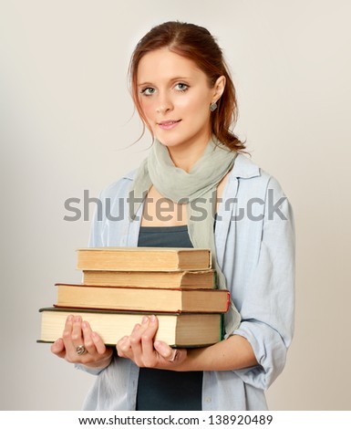 A college girl holding a pile of books, isolated on white