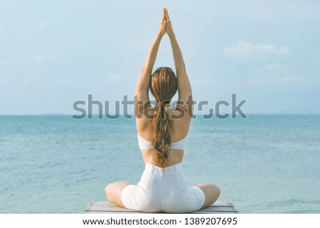 Back of views woman practice yoga lotus pose to meditation summer vacation on pier with sea beach feeling so happiness and cheerful,Travel in tropical beach Thailand,vacations and relaxation Concept