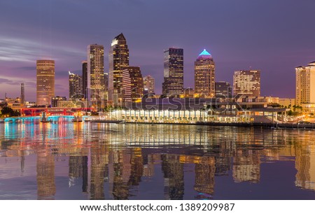 Florida skyline at Tampa with the Convention Center on the riverbank. Lights are reflected in a smooth artificial water  surface
