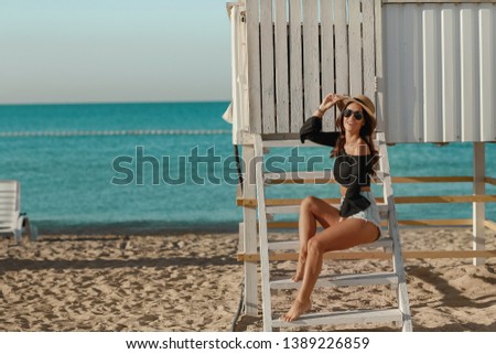 A girl in bikini standing on the beach. Summer holidays and vacation concept.