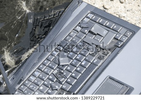 A black laptop with a broken keyboard and cracked display. A close-up picture of part of broken laptop and cracked screen. - Image 