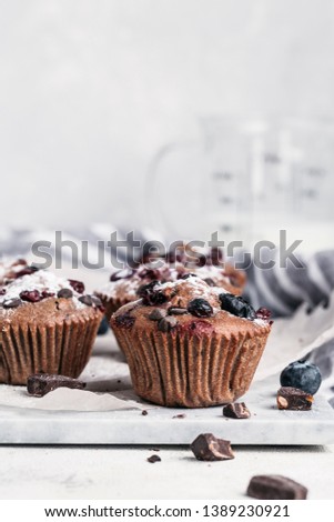 chocolate muffins with cranberry blueberry chocolate pieces table white background Royalty-Free Stock Photo #1389230921