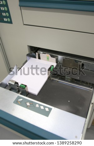 Digital printing press machine takes sheet of paper in action in the printing production line - Image 