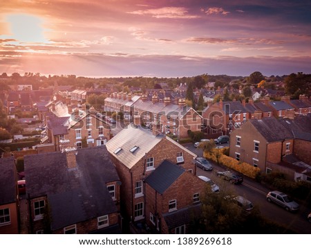 Sun rising above a traditional British housing estate with countryside in the background. Very typically English houses that are over 100 years old. Royalty-Free Stock Photo #1389269618