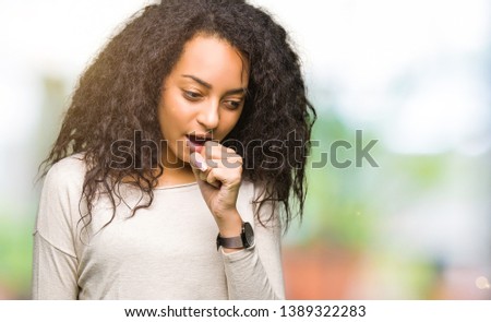 Young beautiful girl with curly hair wearing casual sweater feeling unwell and coughing as symptom for cold or bronchitis. Healthcare concept.