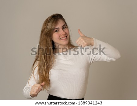 Studio portrait of young beautiful teenager girl woman looking happy showing thumbs up sign and celebration gestures In Happiness, success and human expressions and emotions. Friendly advertisement.
