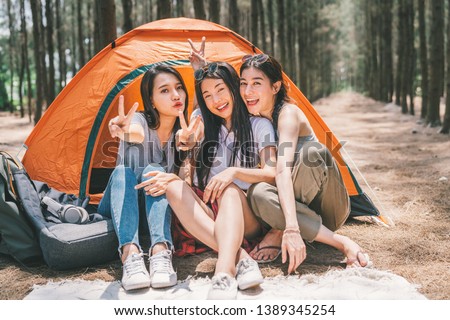 Group of happy Asian teenage girls doing victory pose together, camping by the tent. Outdoor activity, adventure travel, or holiday vacation concept Royalty-Free Stock Photo #1389345254