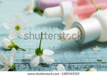 perfume droppers and soap with cherry flowers on old blue wood table