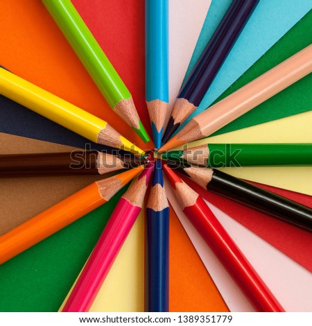 Color pencils on colored paper. Color paper. Origami. Application Multicolored pencils. Back to school. School. Stationery. Place for text. Pencil. View from above. Mock up. Template.