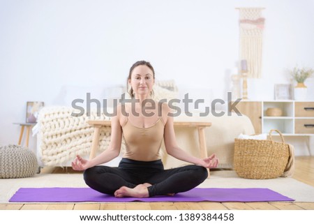 Sport young girl, woman practices yoga indoors at home. Asana yoga, health concept, yoga in my heart.