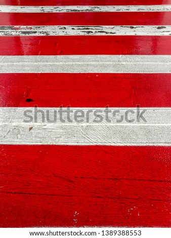 Vertical perspective of red and white painted zebra crossing - abstract design