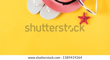 Summer beach composition. Hat, flip flops, sunglasses, starfish on yellow background. Summer holiday concept. Flat lay, top view, copy space