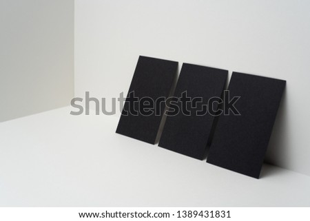 Design concept - perspective view of 3 vertical black business card on white 3D space background for mockup, it's real photo, not 3D render