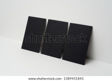 Design concept - perspective view of 3 vertical black business card on white 3D space background for mockup, it's real photo, not 3D render