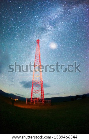 a trip in the mountains at night near the mobile signal tower tower in Ukraine in the Carpathians Ukraine. Metal red design against the background of a huge starry sky is very beautiful