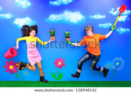 Couple of young people in love running with flowers in their hands.