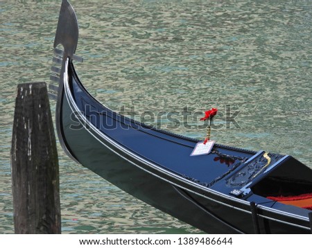 Extreme zoom revealing great detail of masterpiece piano black Gondola cruising Grand Canal, Venice, Italy