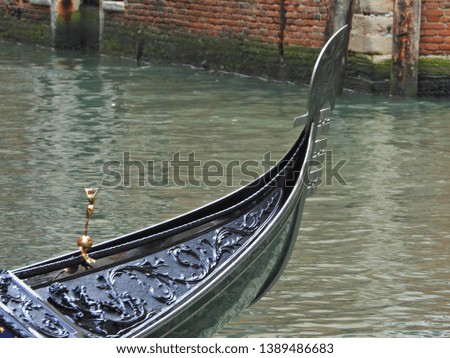 Extreme zoom revealing great detail of masterpiece piano black Gondola cruising Grand Canal, Venice, Italy