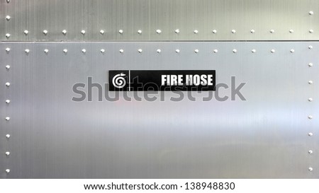 Fire hose label against metal wall