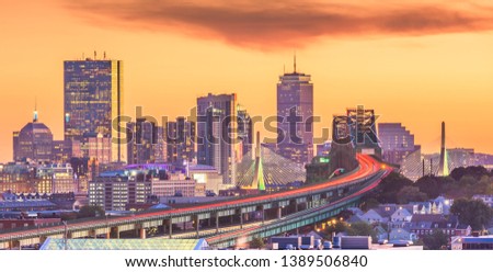 Boston, Massachusetts, USA skyline with bridges and highways at dusk.